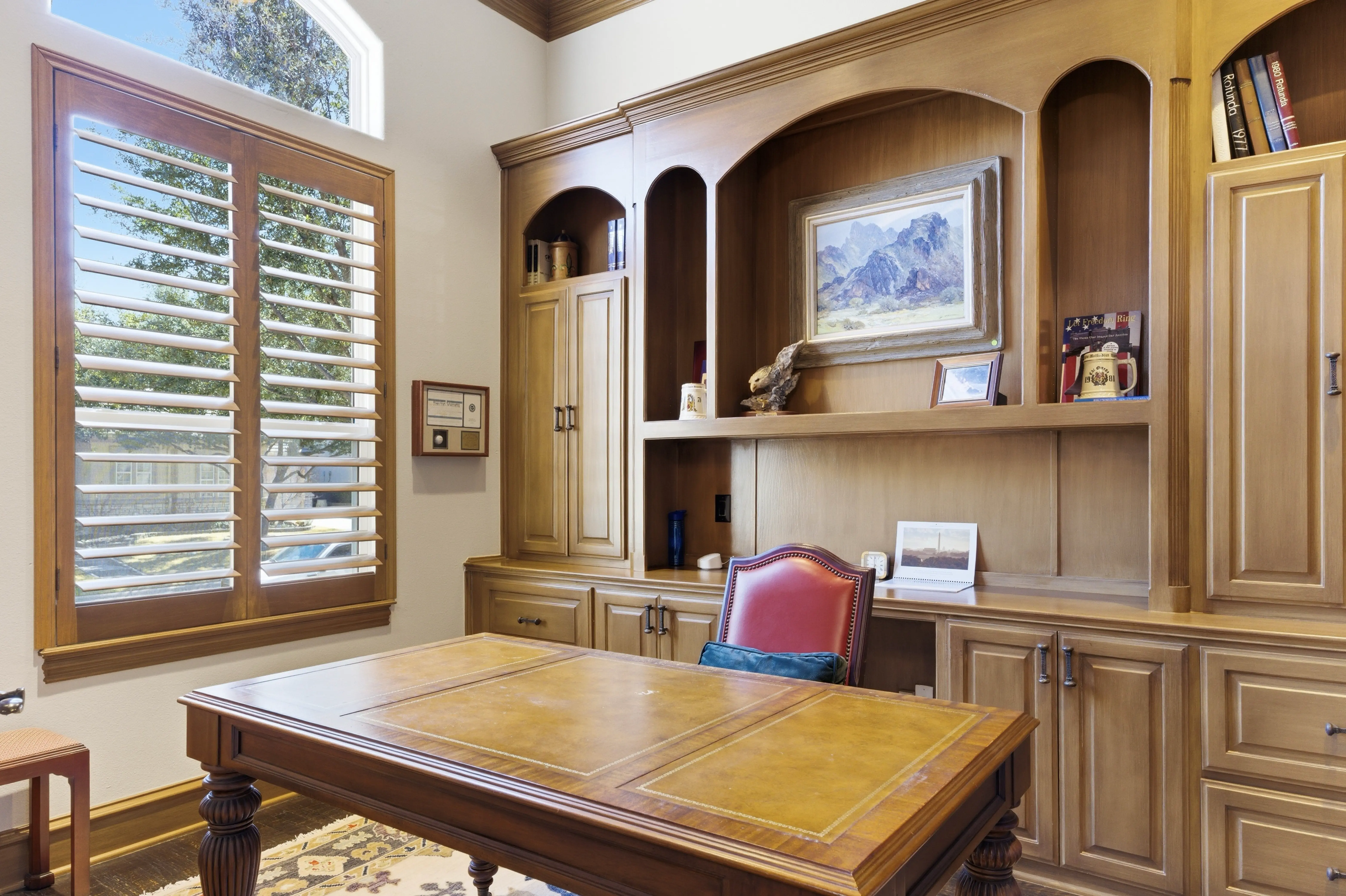 Sophisticated home office with built-in wood cabinetry and arched details